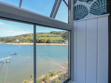 A view from a window showing the sea and hills at 43 The Salcombe in Salcombe