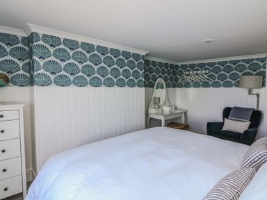 A bedroom with a bed and dressing table at 43 The Salcombe in Salcombe