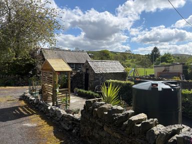 A garden with a wooden shed and water tank at Gwynfa in Ysbyty Ifan