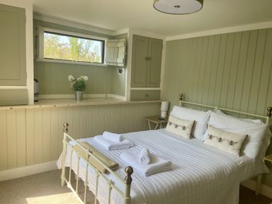 A bedroom with a bed and a lamp at The Cow Shed in Mawgan Porth