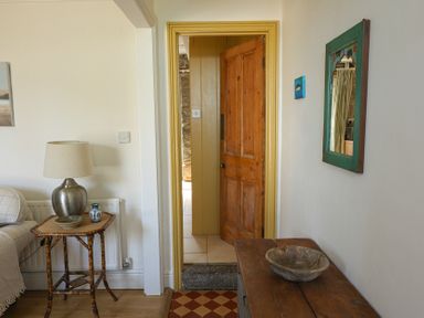A hallway with a door and table at Kittiwake in Newlyn
