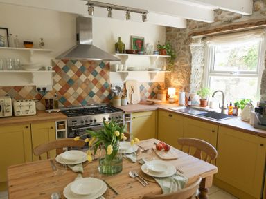 A kitchen with a table and chairs at Kittiwake in Newlyn