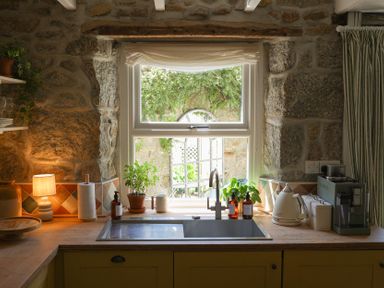 A kitchen with a sink and window at Kittiwake in Newlyn
