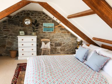 A bedroom with a bed and dresser at Kittiwake in Newlyn