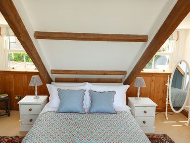 A bedroom with a bed and a mirror at Kittiwake in Newlyn