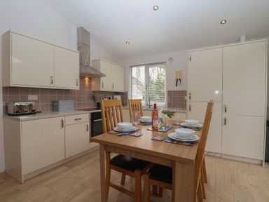 A kitchen with table and chairs at Newton Calm in Newton Ferrers
