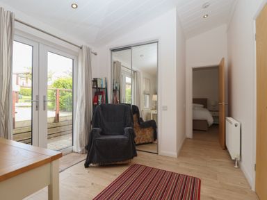 A hallway with double doors and a chair at Newton Calm in Newton Ferrers
