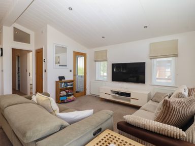 A living room with a television and sofa at Skyview in Newton Ferrers