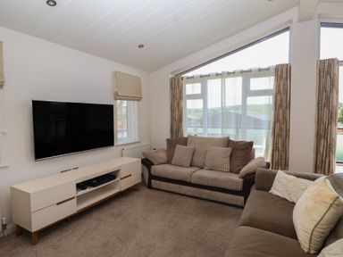 A living room with a sofa and television at Skyview in Newton Ferrers