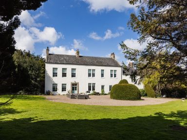 A house with a garden and trees at Cheviot Manor in Akeld near Wooler