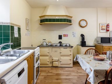 A kitchen with a stove and table at Cheviot Manor Akeld near Wooler