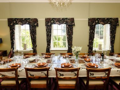 A dining room with a long table set for a meal at Cheviot Manor near Wooler