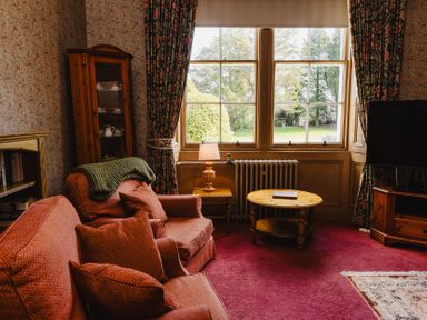 A living room with a sofa and armchair at Cheviot Manor in Akeld near Wooler