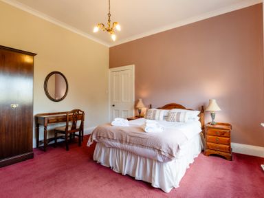 A bedroom with a bed and wardrobe at Cheviot Manor Akeld near Wooler