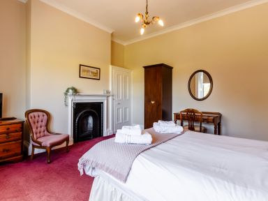 A bedroom with a bed and chair at Cheviot Manor Akeld near Wooler