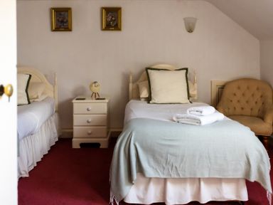 A bedroom with two beds and a nightstand at Cheviot Manor in Akeld near Wooler