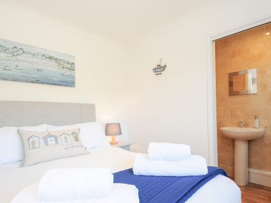 A bedroom with a bed with towels and a blue blanket near a bathroom with a sink at Atlanta near Tintagel