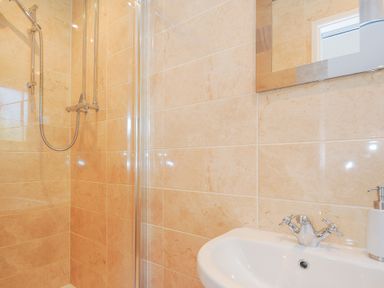 A bathroom with a shower area and a sink with a faucet near a mirror at Atlanta near Tintagel