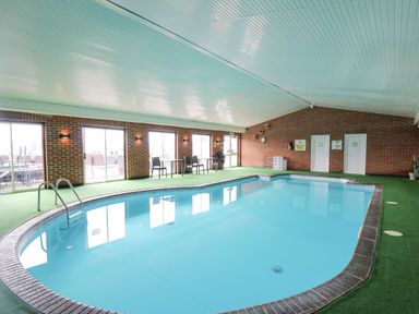 An indoor swimming pool with chairs and tables along the brick wall at 21 Bay View Maenygroes near New Quay Ceredigion