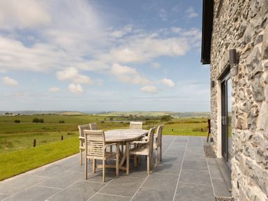 A patio with a table and chairs at Golygfa Cwrt near Bontgoch and Penrhyncoch