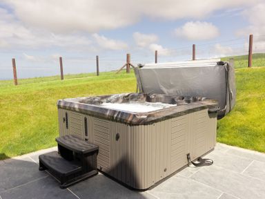 A hot tub with steps in an outdoor setting at Golygfa Cwrt Near Bontgoch and Penrhyncoch