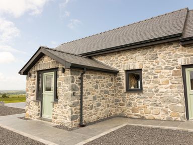 A stone exterior of a house with a door and window at Golygfa Cwrt near Bontgoch and Penrhyncoch
