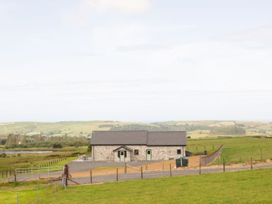 A stone house with a fence and gravel path at Golygfa Cwrt near Bontgoch and Penrhyncoch