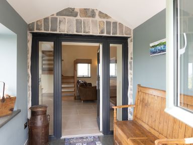 An entrance with a stone wall and a glass door at Golygfa Cwrt near Bontgoch and Penrhyncoch