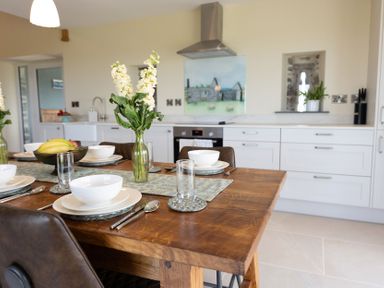 A dining room with a table set for six at Golygfa Cwrt near Bontgoch and Penrhyncoch