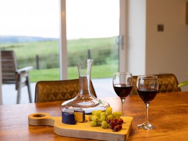 A dining room table with wine and grapes at Golygfa Cwrt near Bontgoch and Penrhyncoch