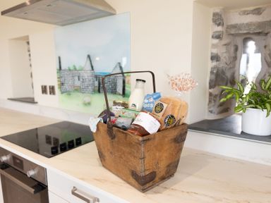 A basket with groceries on a kitchen countertop at Golygfa Cwrt near Bontgoch and Penrhyncoch
