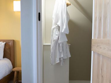 A robe hanging in a bedroom near a bed and nightstand at Golygfa Cwrt near Bontgoch and Penrhyncoch