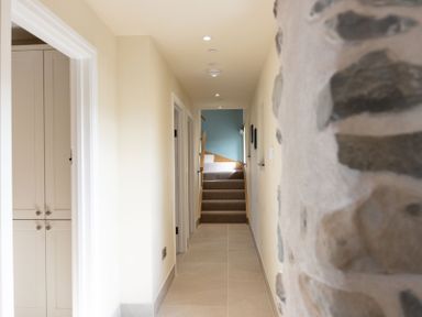 A hallway with a staircase and a closet at Golygfa Cwrt near Bontgoch and Penrhyncoch