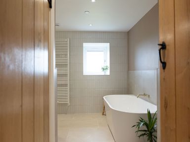 A bathroom with a bathtub and a window at Golygfa Cwrt near Bontgoch and Penrhyncoch