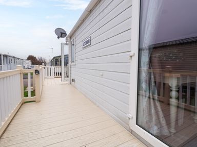 An outdoor deck area with railing and a white door on a mobile home at Hazel Park Lodge HP4 in Rhyl
