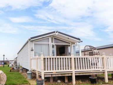 An exterior view of a mobile home with a small porch and railing at Hazel Park Lodge HP4 in Rhyl