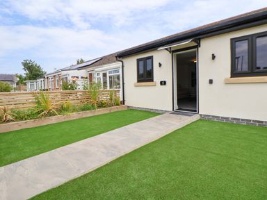 An entrance with a pathway and lawn at 4 Willow Grove - Freehold Talacre