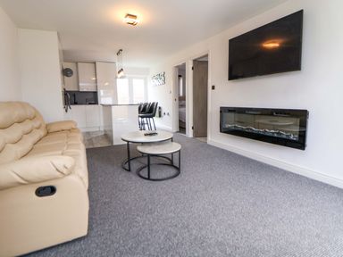A living room with a sofa and coffee table at 4 Willow Grove - Freehold Talacre