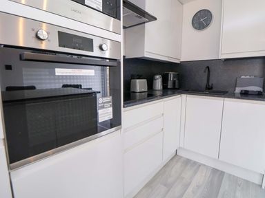A kitchen with built-in oven, microwave, and appliances at 4 Willow Grove - Freehold Talacre