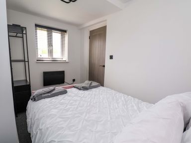 A bedroom with a bed and shelf at 4 Willow Grove - Freehold Talacre