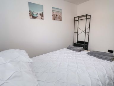 A bedroom with bed and towels at 4 Willow Grove - Freehold Talacre