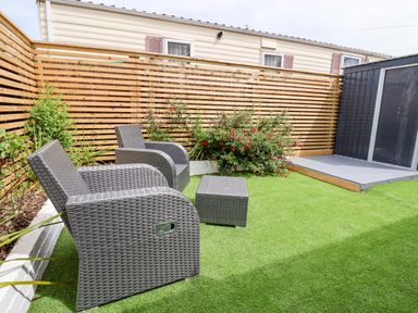 A garden with chairs and a table at 4 Willow Grove - Freehold in Talacre