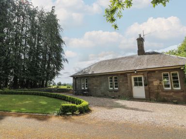 A house surrounded by trees and greenery at Eagle Glen Cottage in Kettins near Coupar Angus