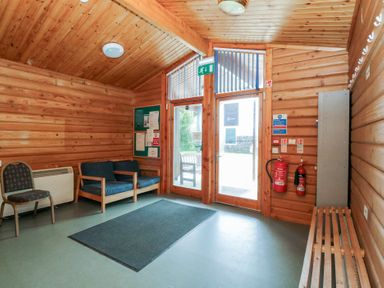 A lobby with seating and a notice board at Shore Lodge in Brodick