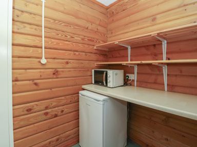 A kitchen with refrigerator and microwave at Shore Lodge Brodick