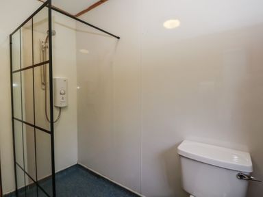 A bathroom with a shower and toilet at Shore Lodge in Brodick