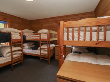 A bedroom with bunk beds and a dresser at Shore Lodge in Brodick