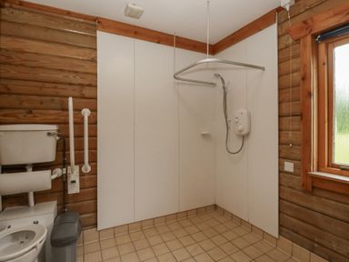 A bathroom with a shower and toilet at Shore Lodge in Brodick
