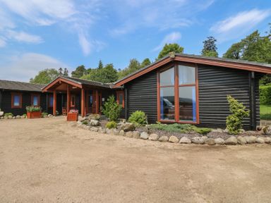 An outdoor view of a house with plants and a pathway at Shore Lodge in Brodick
