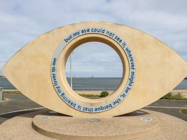 A large eye-shaped sculpture with text displayed along the inner circle by the beach at The Beach Apartment in South Shields